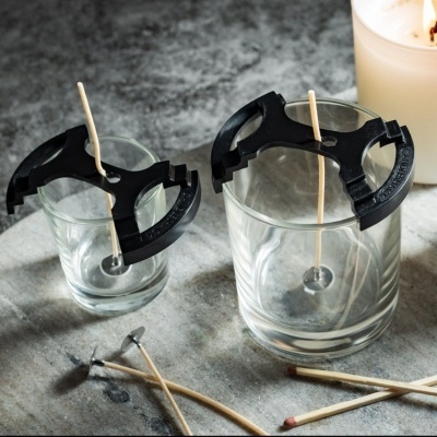 Suportes de silicone para apagar velas em copos transparentes com cavilhas de madeira ao redor