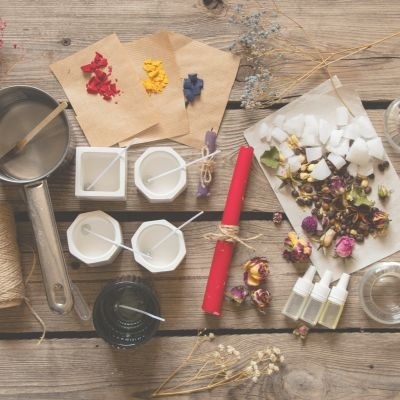 Materiais para fazer velas dispostos sobre uma mesa de madeira