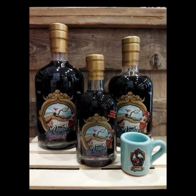 Três garrafas de licor Mocha Rojo e uma caneca azul clara com desenho em fundo de madeira