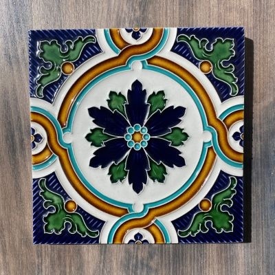 Azulejo cerâmico quadrado com padrão floral em azul, verde e amarelo
