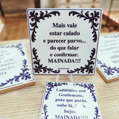 Azulejo de cerâmica com moldura azul e texto humorístico em português