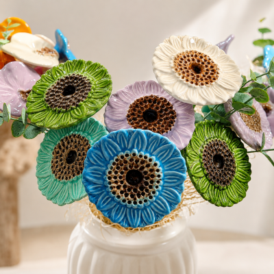 Flores decorativas em cerâmica colorida dentro de um vaso branco