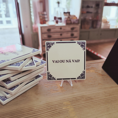 Azulejo branco com bordas azuis e texto 'VAI OU NÁ VAI?'