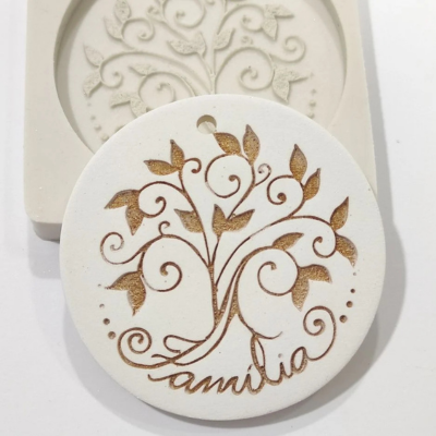 Moldes silicone bege e peça branca circular decorada com árvore e palavra Família