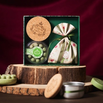 Conjunto de presente com cápsulas verdes e saco de tecido floral