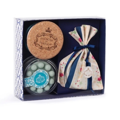 Conjunto com frasco de cortiça, recipiente com bolinhas brancas, saco de tecido com padrão floral e caixa azul e branca