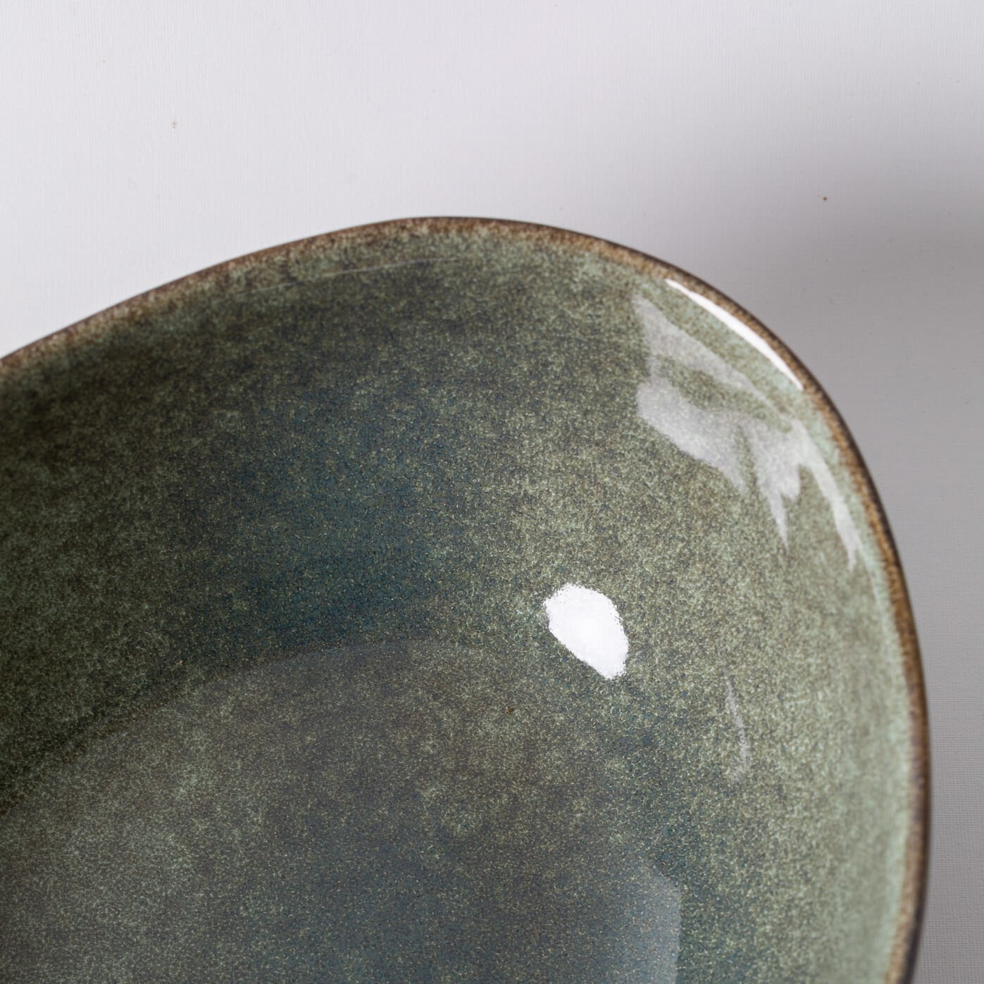 Taça para servir feita à mão Prato de cerâmica verde com brilho e borda irregular.