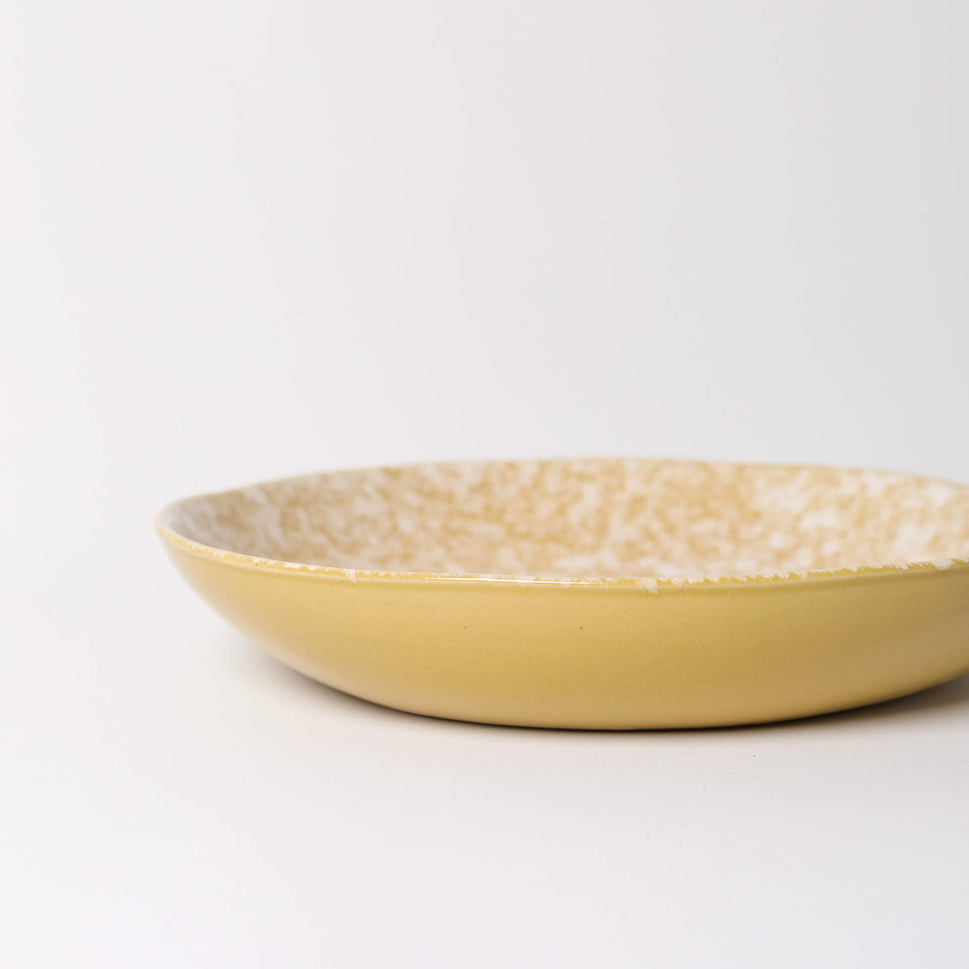 Pratos de sopa feitos à mão Prato raso amarelo com padrão marmoreado interior.