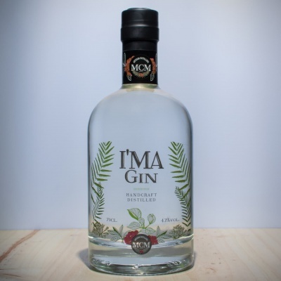 Garrafa de gin I'MA GIN com folhas verdes e frutos vermelhos na etiqueta.