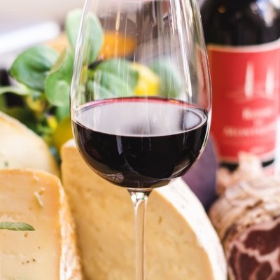 Taça de vinho tinto com queijos e enchido