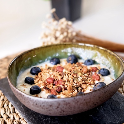 Tigela de cerâmica com iogurte, granola e mirtilos