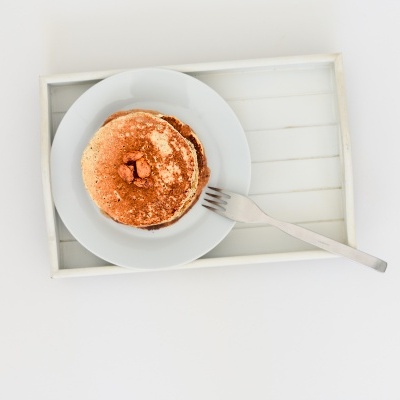 Panquecas com manteiga numa tigela branca sobre bandeja branca