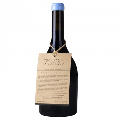 Garrafa de vinho escura com tampa azul e etiqueta pendurada de papel castanho