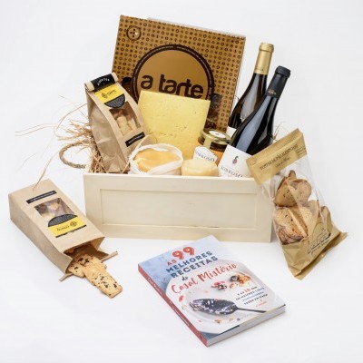 Cesto de madeira com queijo, vinho, bolachas, pão seco, caixa de pizza e livro de receitas