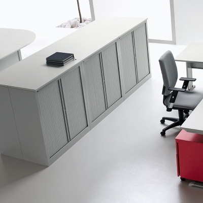 Escritório moderno com mesas em L, cadeiras pretas e armário branco grande