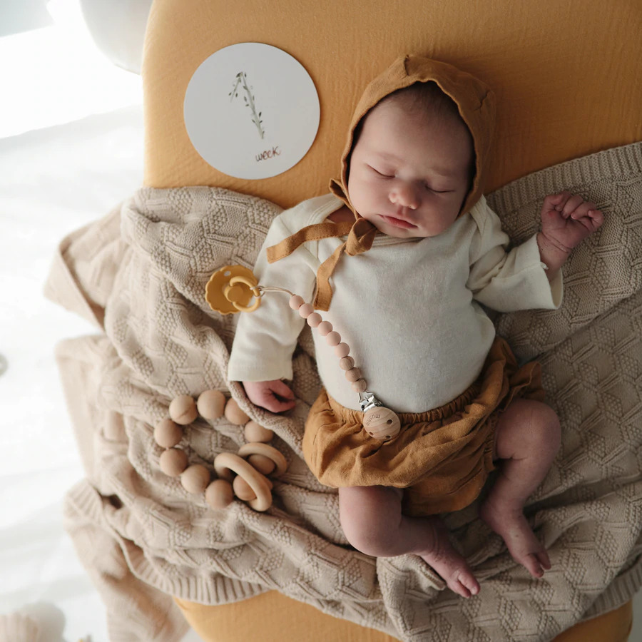 CARTÕES MILESTONE Bebé adormecido com roupa branca e castanha alaranjada numa manta bege tricotada