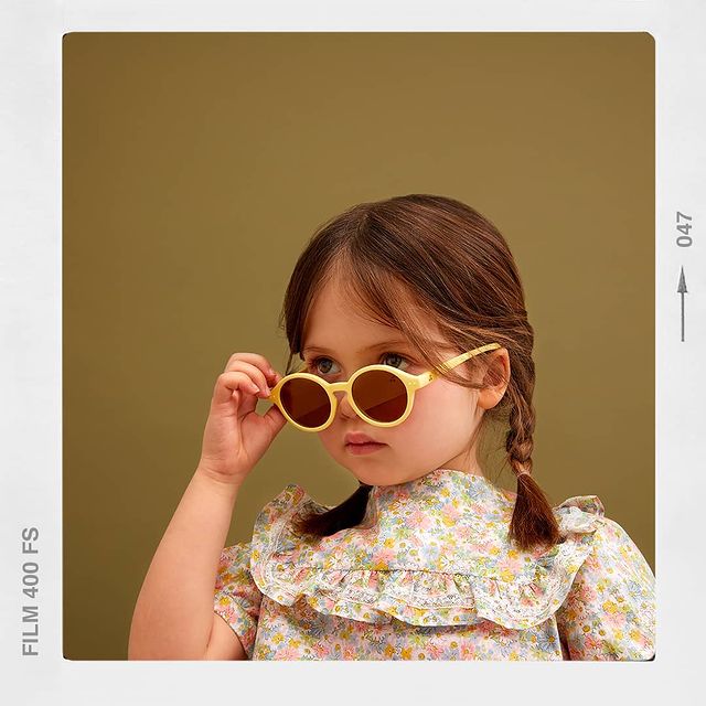 ÓCULOS IZIPIZI | KIDS Menina com óculos de sol amarelos e vestido floral