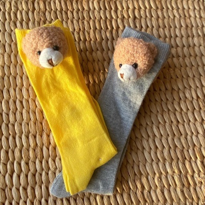 Meias infantis amarelas e cinza com cabeças de urso de pelúcia