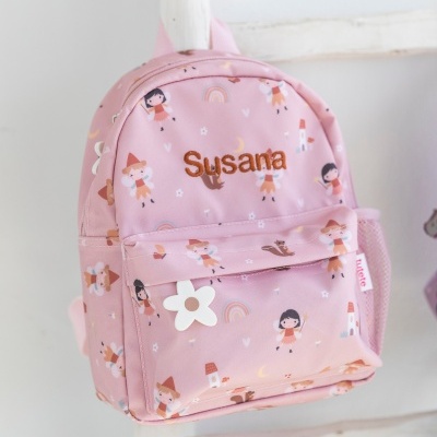 Mochila rosa infantil com padrão de bonecas e nome Susana bordado