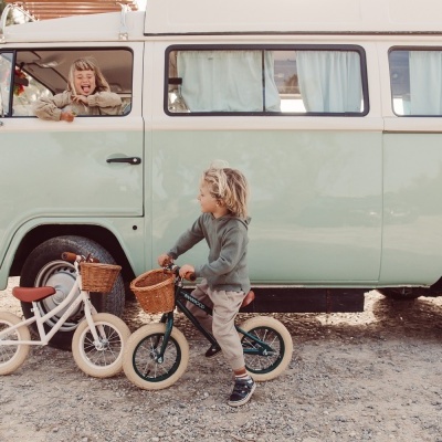Bicicletas infantis com cestos junto a carrinha clássica verde-água