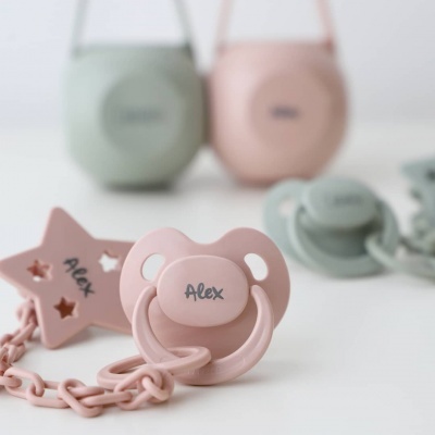 Chupeta rosa personalizada com clip e bolsas para chupetas ao fundo