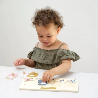 Criança a brincar com puzzle de madeira com peças coloridas