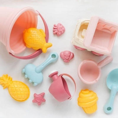 Brinquedos de praia coloridos feitos de plástico sobre fundo branco