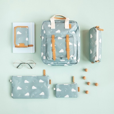 Conjunto azul-petróleo com padrão branco e detalhes castanhos incluindo mochila, carteira, estojo, caderno e acessórios.