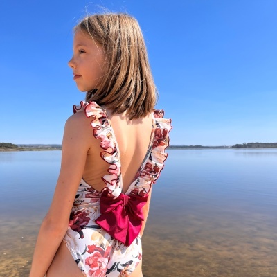 Fato de banho infantil floral com folhos e laço vermelho nas costas