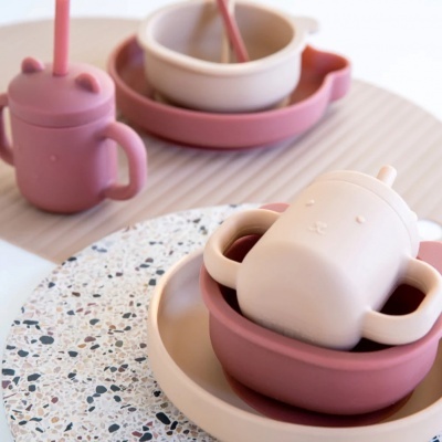 Utensílios para bebé em silicone rosa e bege com pratos e suportes redondos azulejados