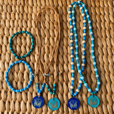 Colares e pulseiras com contas azuis e verdes e pendentes com desenho de carrinha clássica