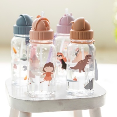 Quatro garrafas de plástico com tampa colorida e desenhos infantis sobre bancada branca