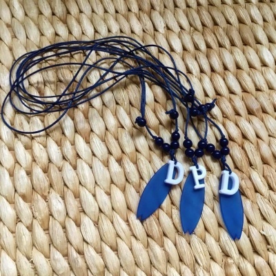 Colares com pendentes de pena azul escuro com letra D branca