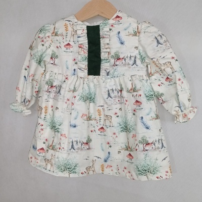 Vestido infantil branco com padrão natural colorido e detalhe verde