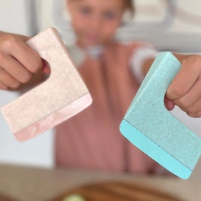 Duas espátulas de silicone coloridas seguradas por uma criança