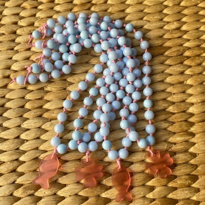 Colar com contas azuis claras e pendentes vermelhos translúcidos em formas de peixe e flores
