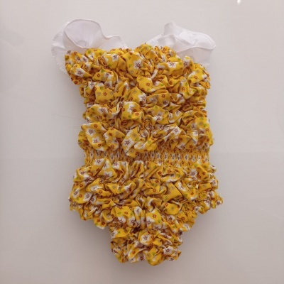 Fato de banho bebé amarelo com flores pequenas e alças brancas transparentes.