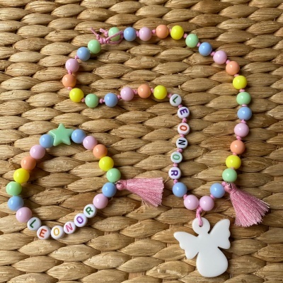 Colar e pulseira com contas coloridas, letras LEONOR, borboleta branca e estrela verde sobre palha