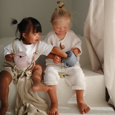 Duas crianças sentadas com máquinas fotográficas rosa e azul