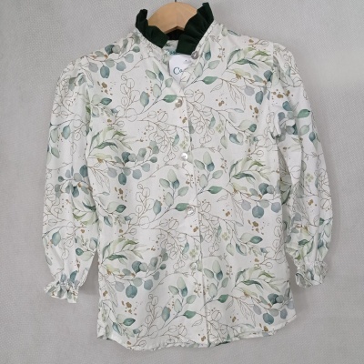 Camisa feminina branca estampada com folhas verdes, gola plissada verde escura e botões brancos.