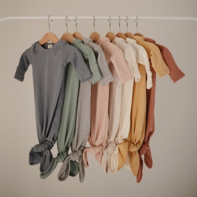 Bodies de bebê de manga comprida em várias cores pendurados em cabides