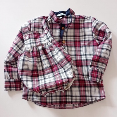 camisa xadrez branca, vermelha e azul com botões castanhos sobre fundo branco