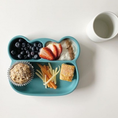 Prato de silicone com várias comidas e copo branco