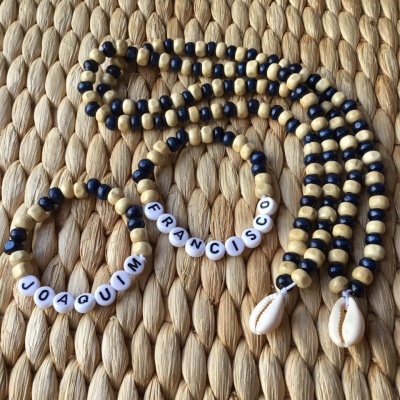 Colar e pulseiras de contas de madeira bege e preto com búzios e nomes em letras brancas