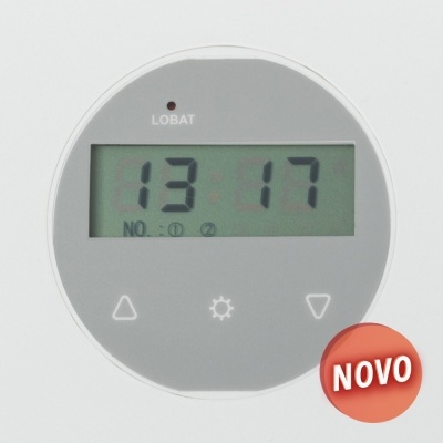 Relógio digital redondo com visor cinzento a mostrar 13:17 e etiqueta vermelho com 'NOVO'.