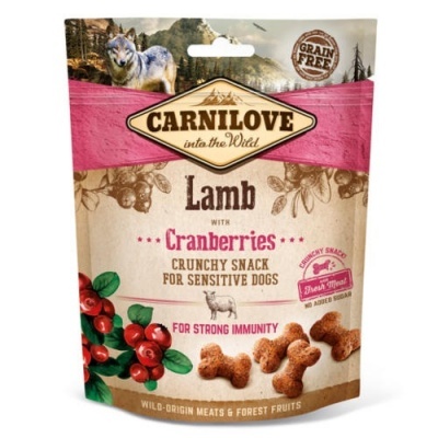 Embalagem de snack para cães Carnilove Lamb com Cranberries, cores creme e rosa, com imagens de frutos vermelhos e texto em inglês.