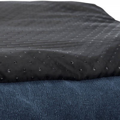 Tecido preto com pontos em relevo sobre tecido azul escuro