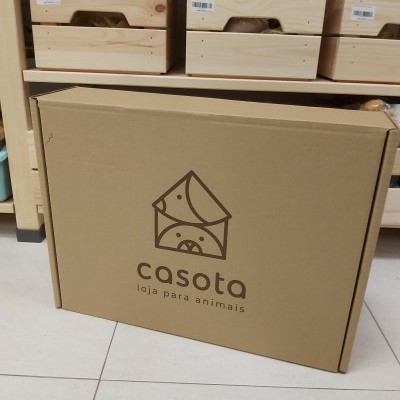Caixa de cartão com logotipo casota e prateleira de madeira com caixas de madeira