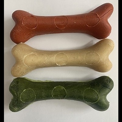 Três ossos de cão coloridos alinhados sobre fundo branco