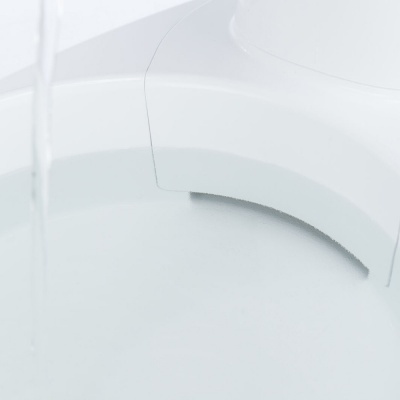 Dispensador de água branco a escoar água para recipiente branco